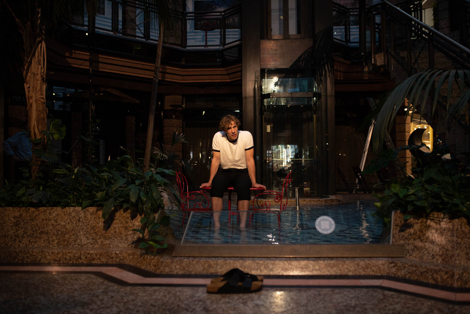 Schauspieler Jakob Tögel auf der Bühne mit den Füßen im Wasser