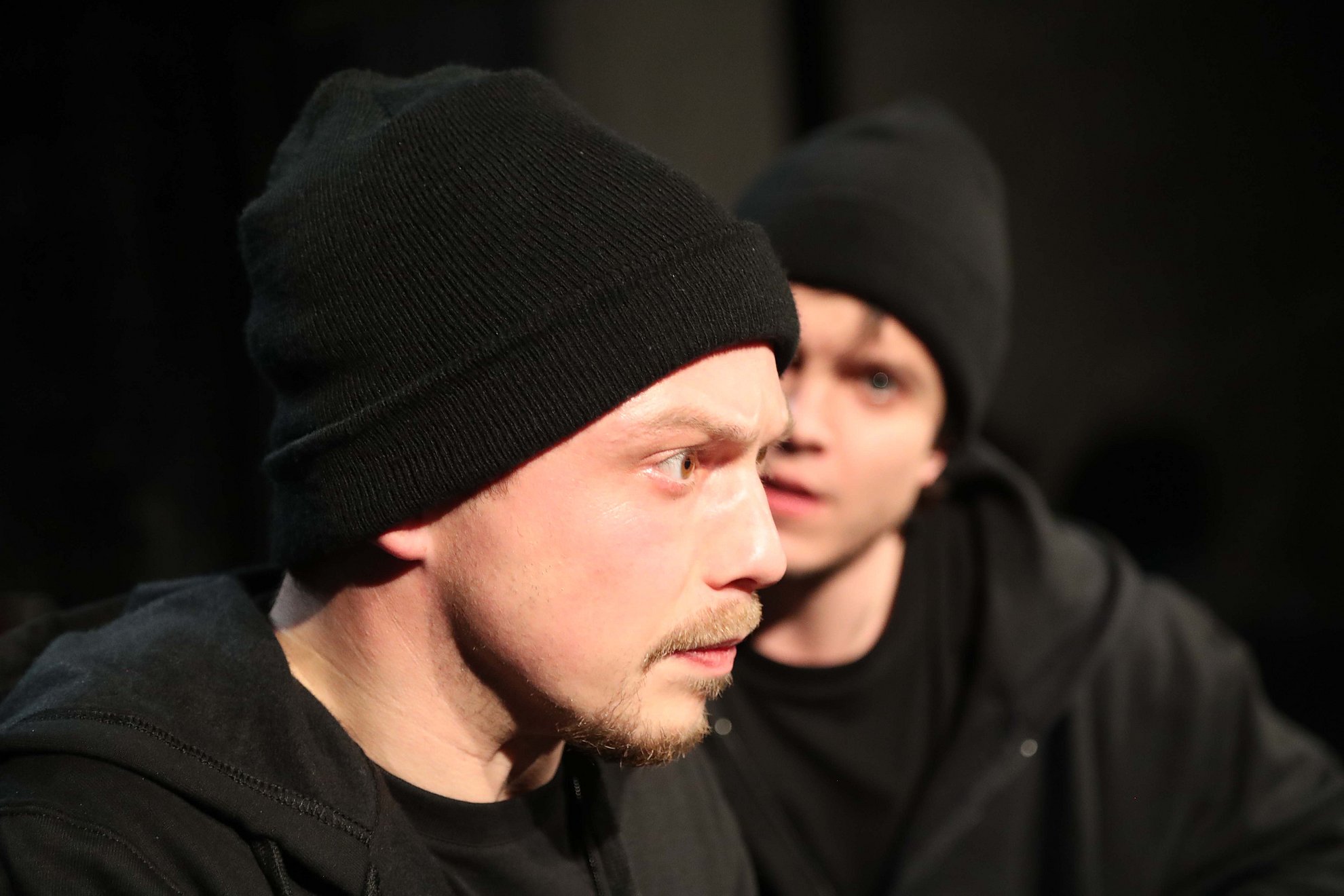 Zwei Darsteller von Jona, ganz in schwarz gekleidet, im Zwiegespräch